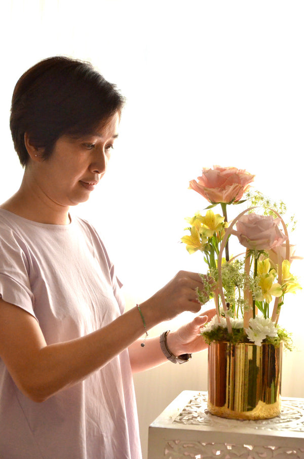 Beginner floristry course, student working on a vertical design with roses, alstroemeria, spray chrysanthemum and ammi majus