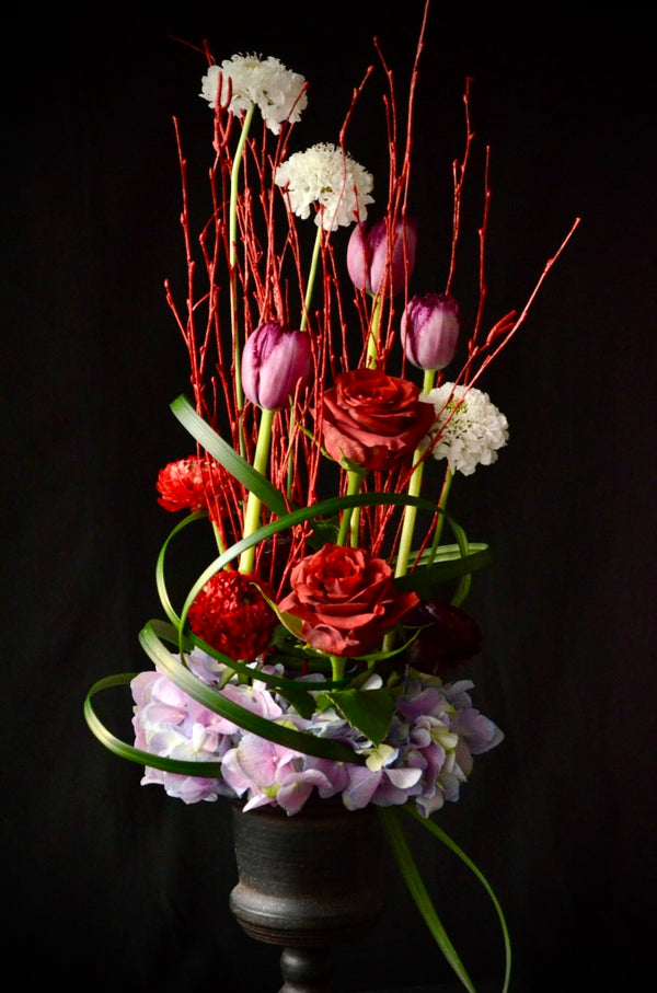 Beginner floristry course, vertical design with birch twigs, roses, tulips, hydrangeas and didiscus