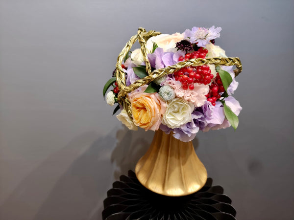 Intermediate floristry course, bouquet in bouquet holder with hydrangeas, roses, viburnum berries and scabiosa, featuring bear grass braiding technique