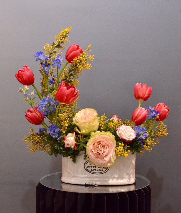 Intermediate floristry course, crescent shape flower arrangement with roses, tulips, delphiniums and acacia