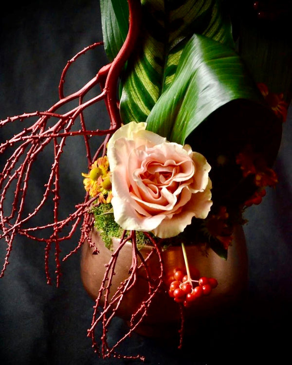 Intermediate floristry course, vertical flower arrangement with dried and painted alexander palm seeds, roses and viburnum berries, featuring leaf manipulation technique