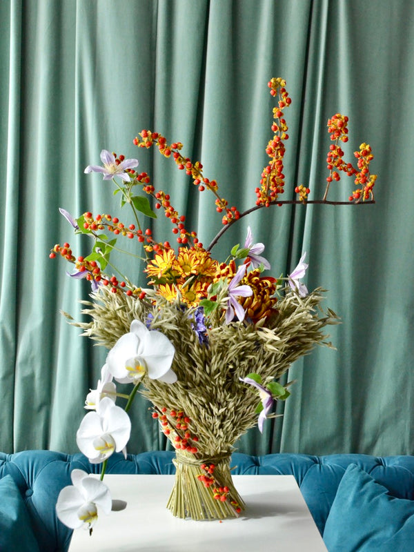 Intermediate floristry course, vase arrangement with dried oat, celastrus, hydrangeas, chrysanthemums, helenium, clematis and phalaenopsis orchids