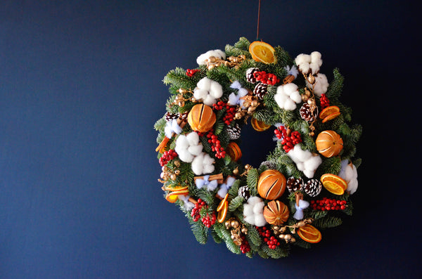 seasonal wreath workshop, classic christmas wreath with cinnamon sticks, cotton flowers, ilex berries, pine cones and oranges, used as a table centrepiece